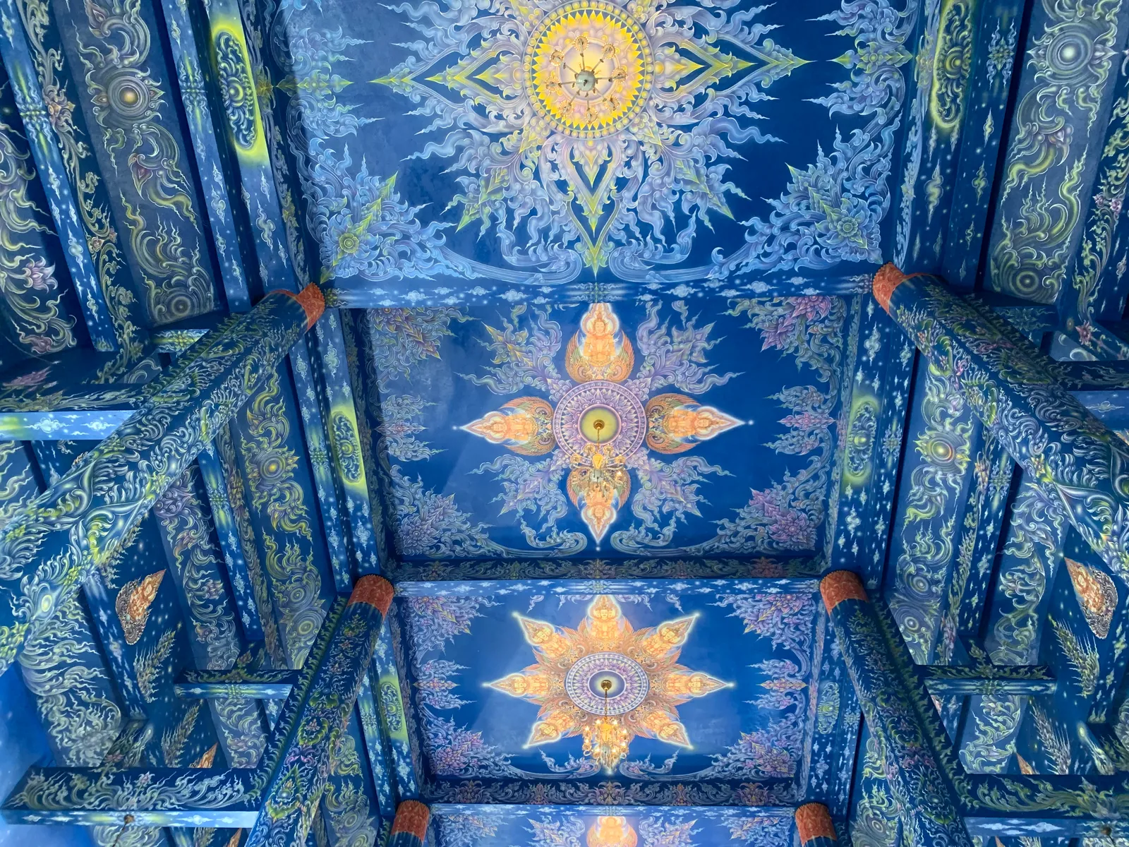 Blue ceiling painted with gold sun patterns and green scrollwork