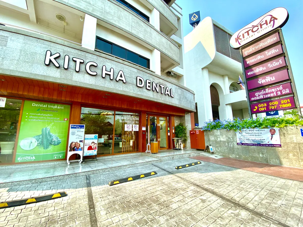 The street front of a clinic with a large Kitcha Dental sign above a glass entrance.