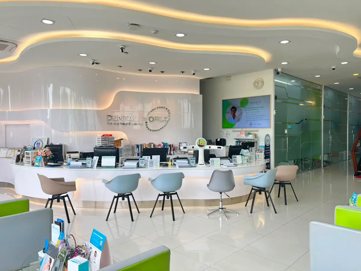 A curved white reception desk with pale blue chairs and a lit ceiling.