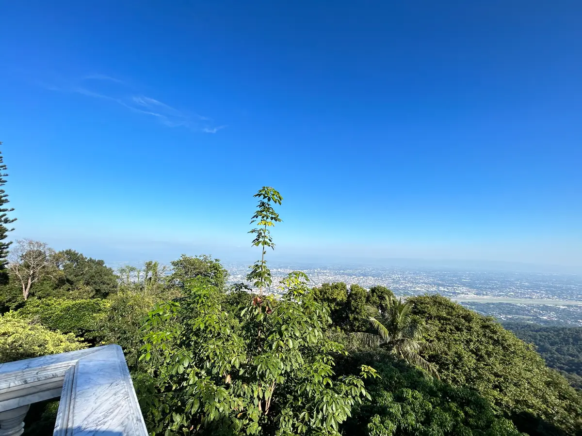 View over forested slopes to the Chiang Mai valley under a clear blue sky