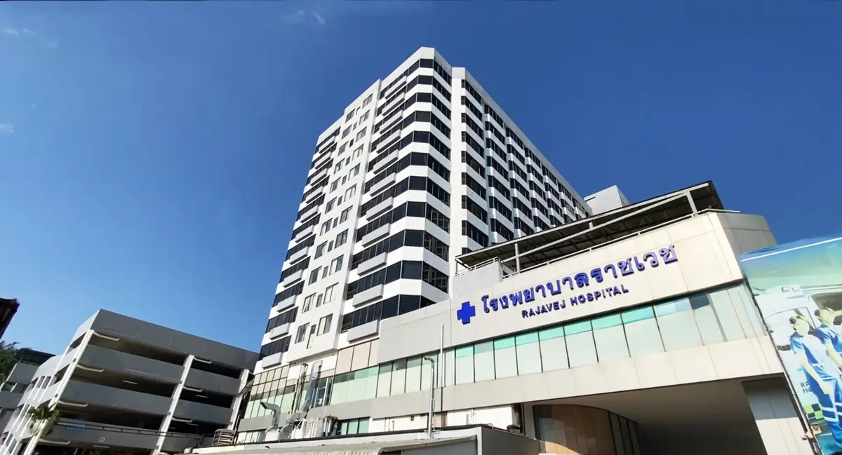 Tall white hospital building with a blue Rajavej Hospital sign on the lower front