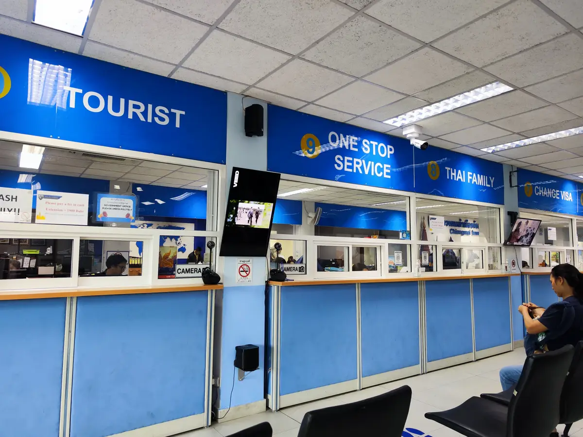 Rows of blue service counters with Tourist, One Stop Service and Thai Family signs.