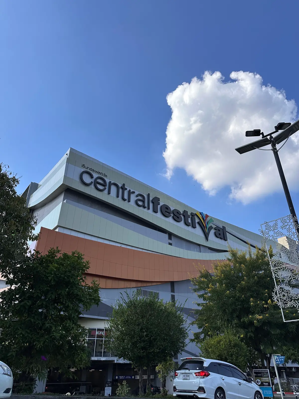 Front of the Central Chiangmai mall with a large lettered sign on a pale facade under a blue sky.