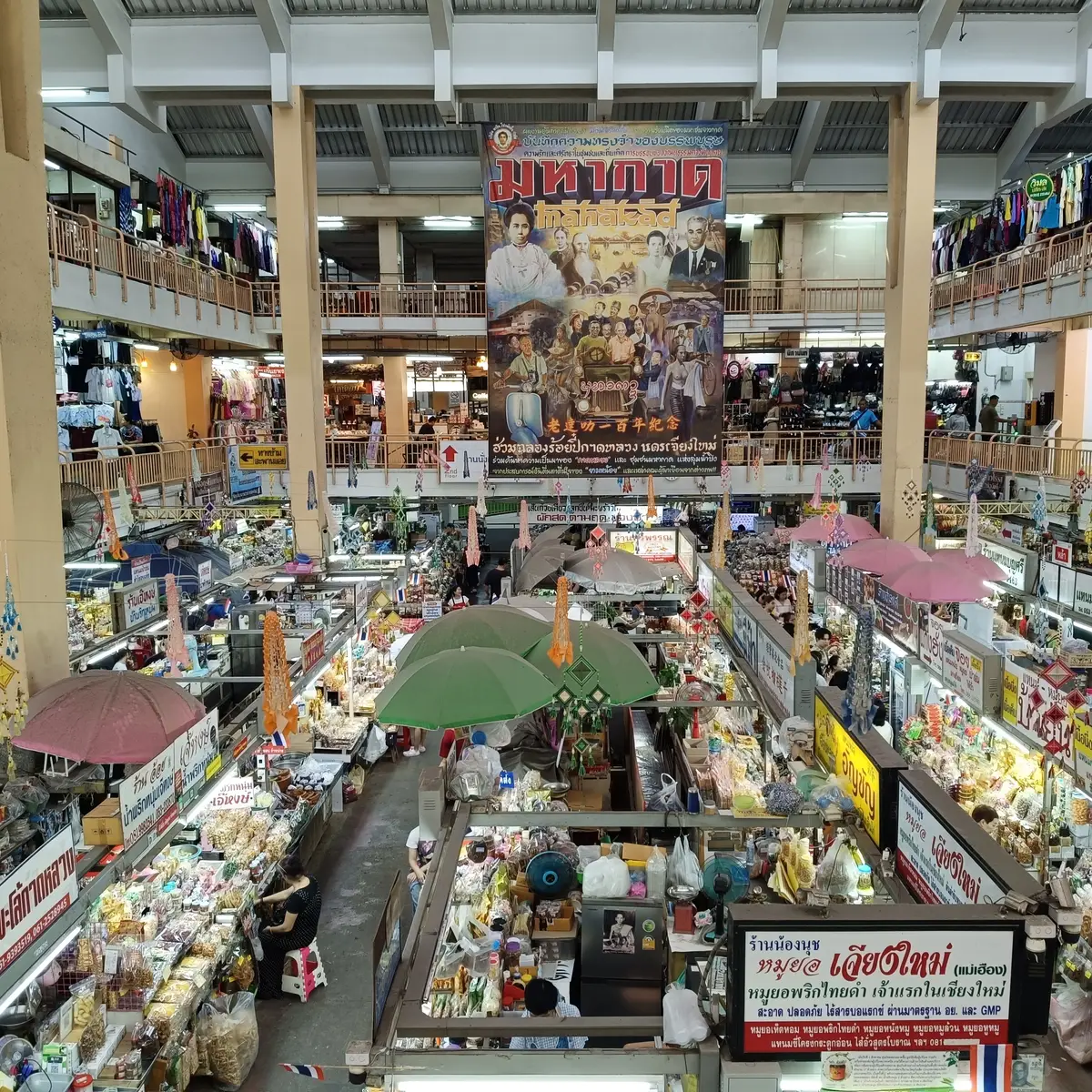 View down into the central hall of Warorot Market from an upper floor, with rows of stalls and umbrellas below.